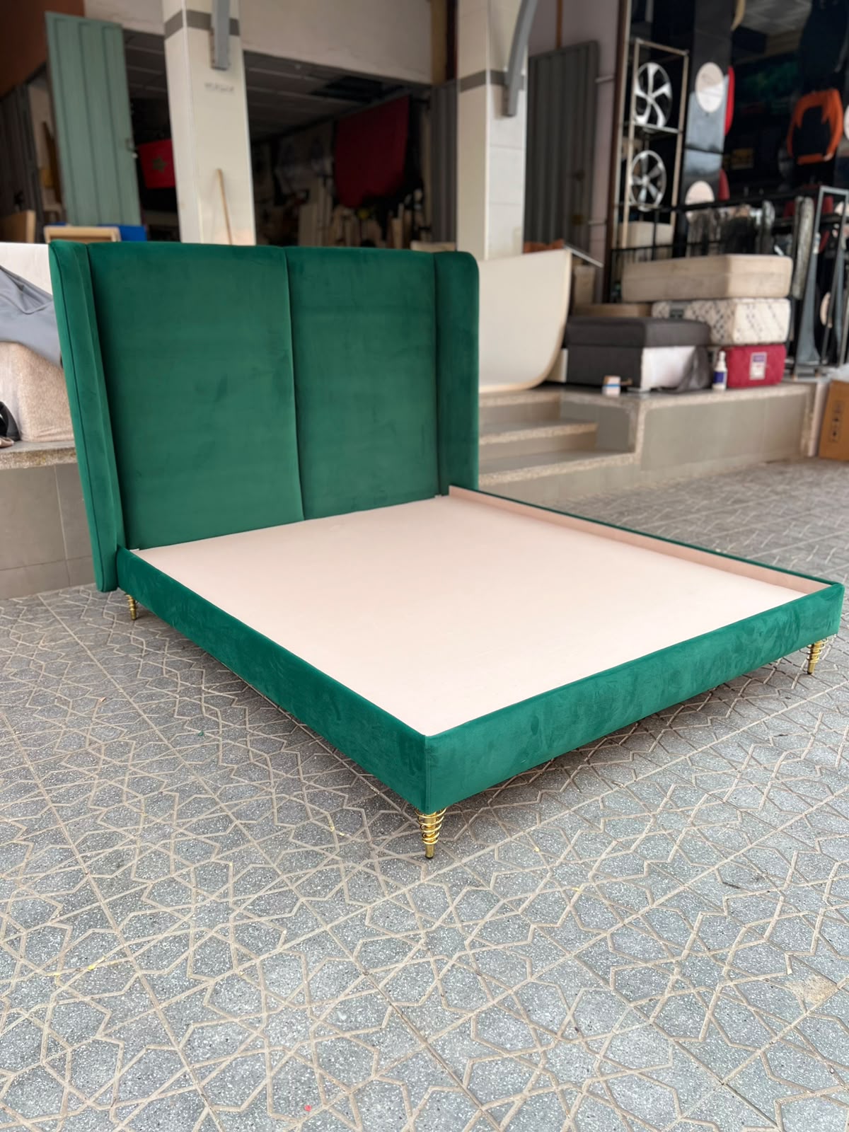 Lit tapissé en velours vert avec pieds dorés